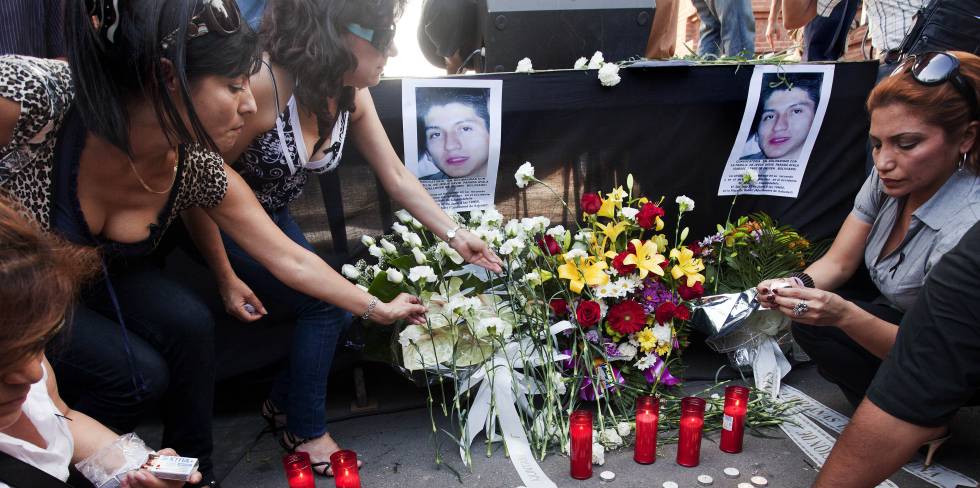 una mujer deposita flores ante la foto de Jesús Parada, uno de los fallecidos en el accidente ferroviario que causó 12 muertos en la estación de Castelldefels, Barcelona, en 2010.