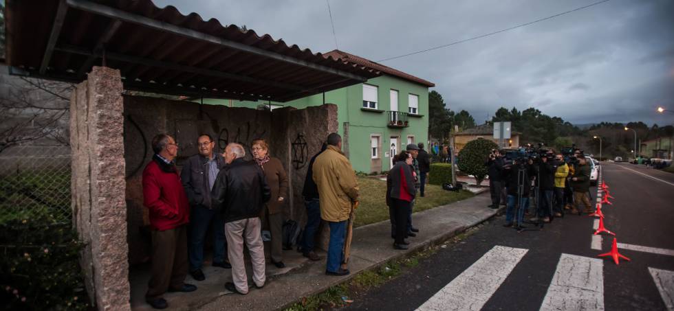 Vecinos de Tarago (Rianxo), observan desde la parada del bus la casa del detenido por la desaparición de Diana Quer.