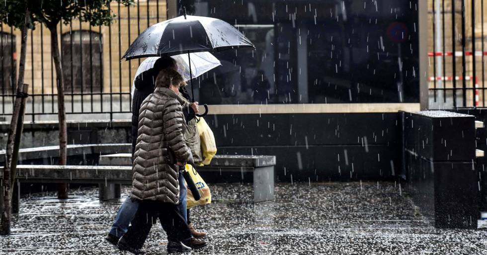 Dos personas se protegen de la intensa granizada caída en Bilbao el pasado diciembre.