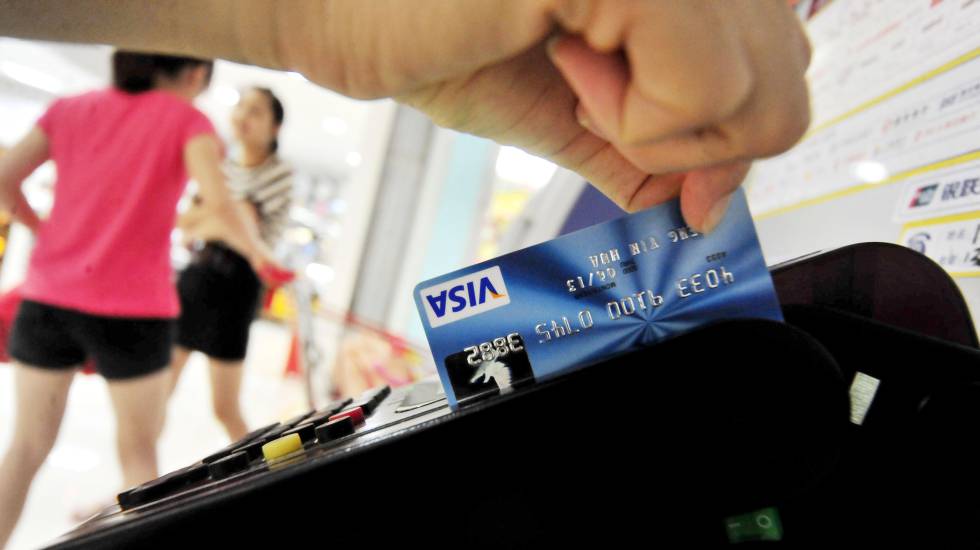 Un hombre paga con una tarjeta de crédito.