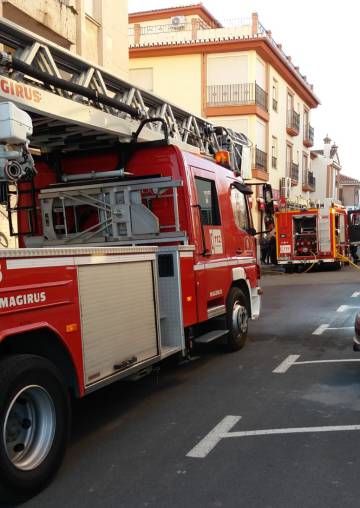Camiones de bomberos frente a la vivienda incendiada, en Albolote.