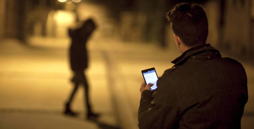 Un joven envía un mensaje con su teléfono móvil.