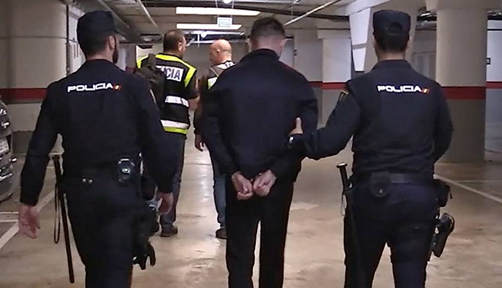 Agentes de la PolicÃ­a Nacional trasladan a un detenido acusado de fraude.