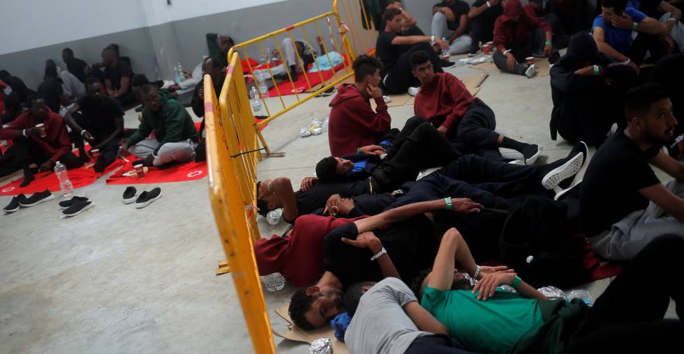 Un grupo de migrantes interceptados en el Estrecho de Gibraltar esperan en una nave del puerto de Barbate (Cádiz) el pasado sábado.