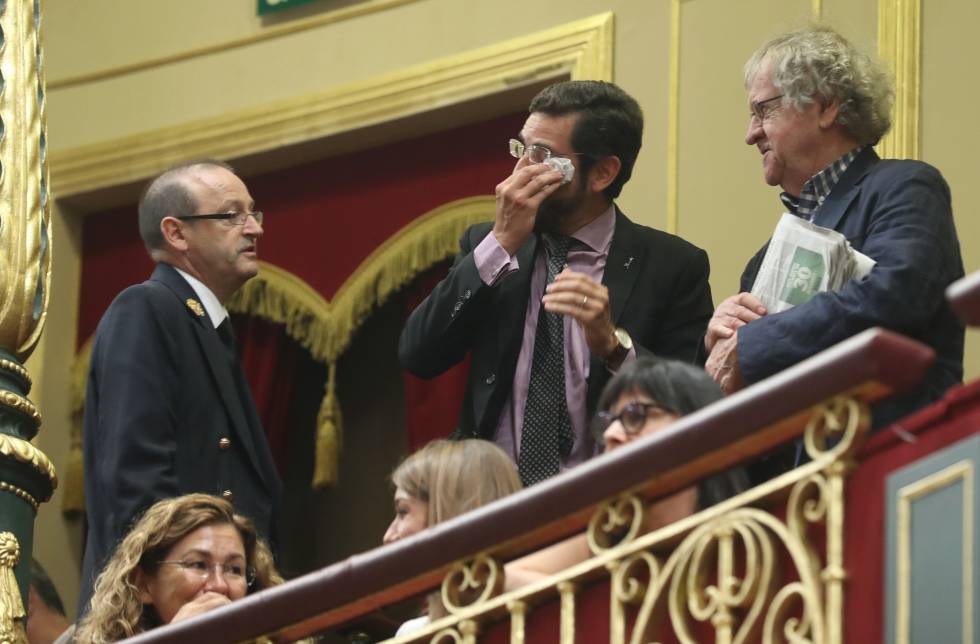 Ian Gibson (derecha), junto con Eduardo Ranz, abogado de la familia La Peña (centro) y el ujier del Congreso, en la tribuna de invitados del Congreso tras la aprobación de la exhumación de Franco del Valle de los Caídos.