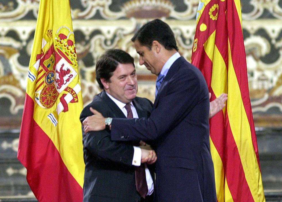 El expresidente del Gobierno Valenciano José Luis Olivas (izquierda) abraza a su antecesor, Eduardo Zaplana, tras entegarle la Alta Distinción de la Generalitat, en Valencia en 2002. 