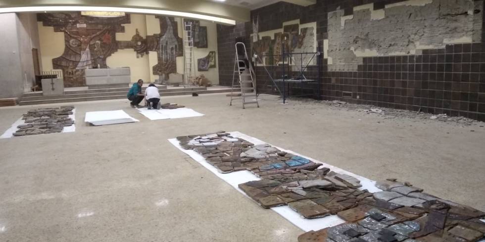 Unos operarios retiran las piezas de cerámica del retablo de la iglesia Cristo Rey de Bilbao.