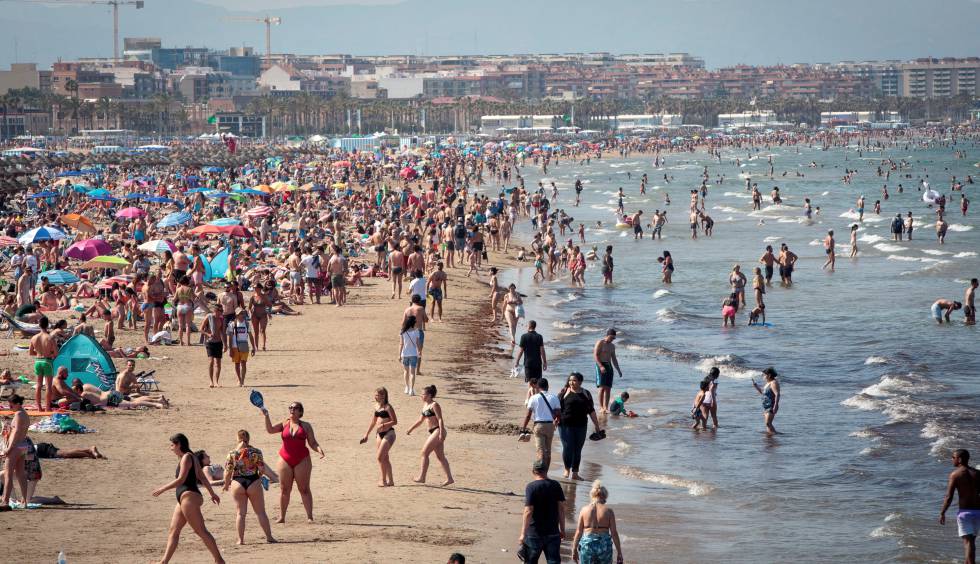 Miles de personas disfrutan este sábado de las altas temperaturas en la playa de la Malvarrosa de Valencia.