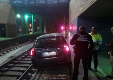 Un hombre circula con su coche por la vía del tren hasta la estación sevillana de Santa Justa