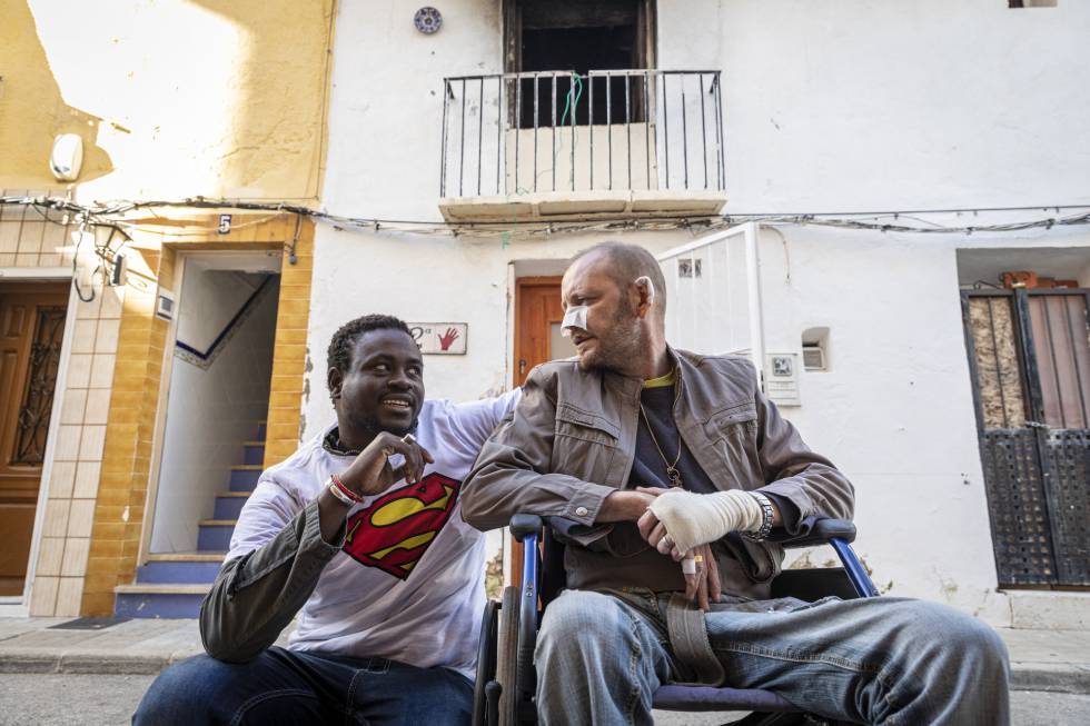 El senegalés Gorgui Lamine Sow y el hombre al que salvó Alex Caudeli, este martes, frente a la casa incendiada.