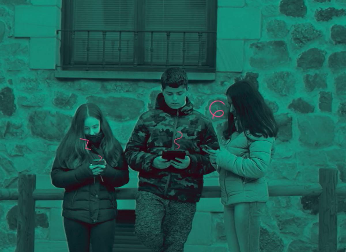 Leyre Arribas y los hermanos Paula y Sergio Terrazas usando sus móviles en una calle de Molinos de Duero (Soria).