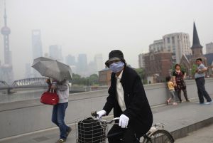 La contaminación de Shanghai obliga a una ciclista a usar mascarilla.