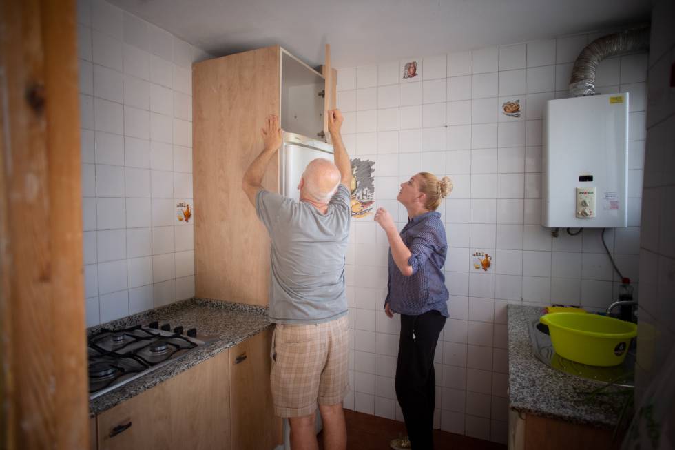 Joaquín Fontiberio ayuda a montar la cocina de la que va a ser su casa, junto a la voluntaria Raquel Sáez.