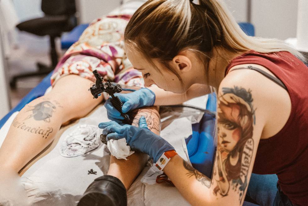 Una artista realiza un tatuaje en la feria Mulafest. 