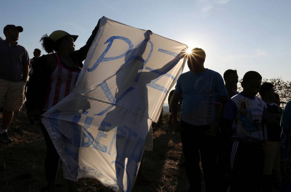 Manifestantes sujetan una pancarta pidiendo 'Paz' en la frontera entre Venezuela y Brasil.  