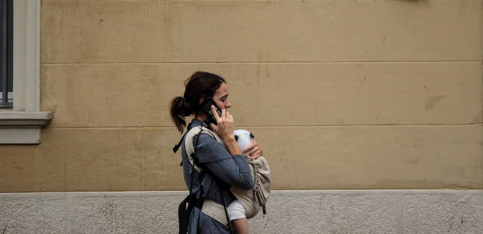 Una mujer pasea con su bebé por Barcelona.