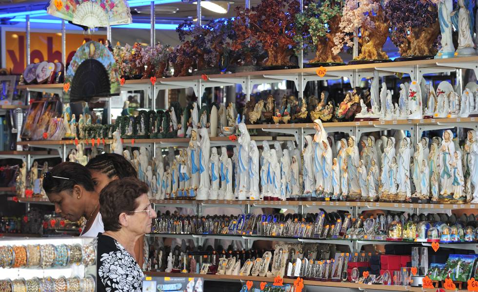 Visitantes de Lourdes, en una tienda de recuerdos, cerca del santuario.