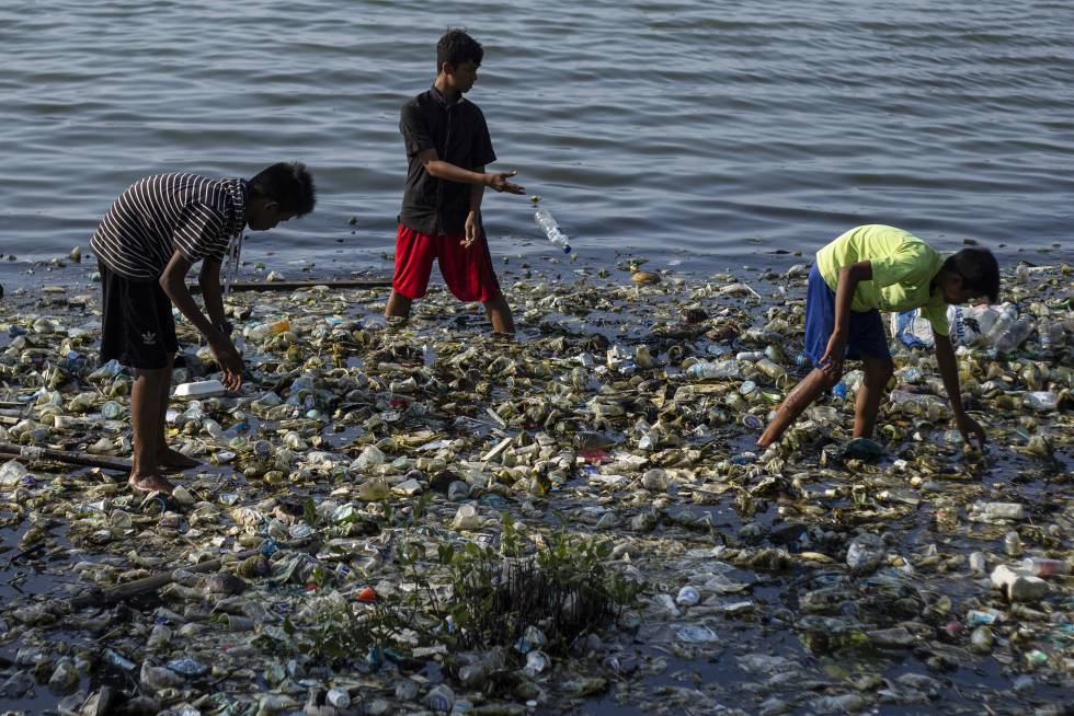 NiÃ±os buscan entre la basura en el agua en Indonesia. 