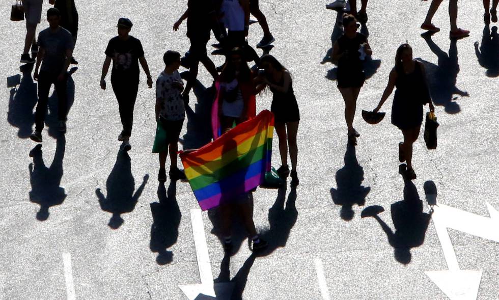 Varias personas sostienen una bandera arcoiris en el desfile del Día del Orgullo Gay en julio de 2018 en Madrid.
