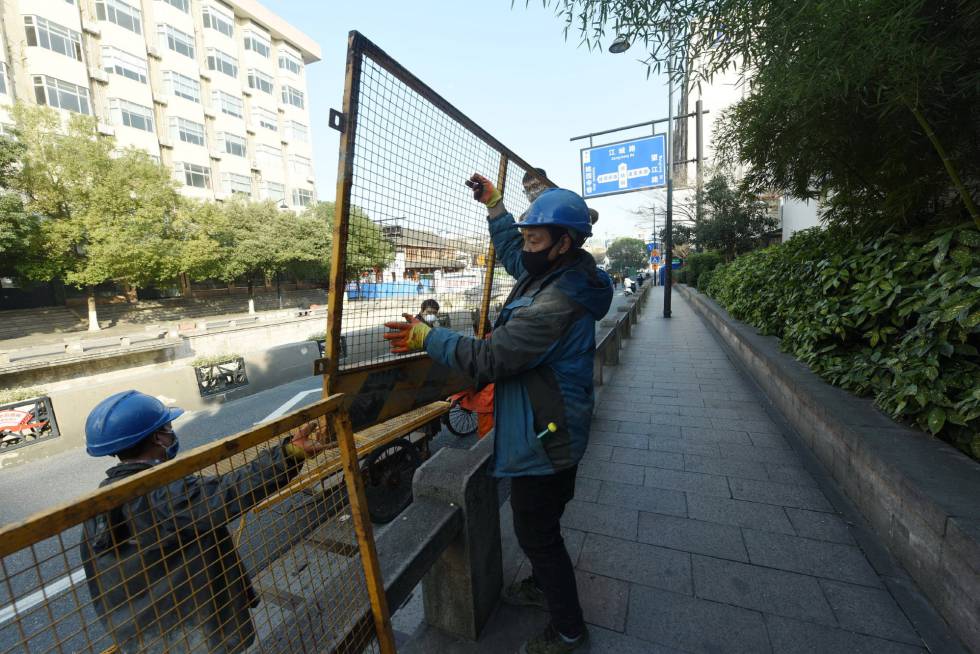 Trabajadores de Hangzhou instalan vallas en las carreteras para impedir la movilidad y hacer frente a la expansión del coronavirus.