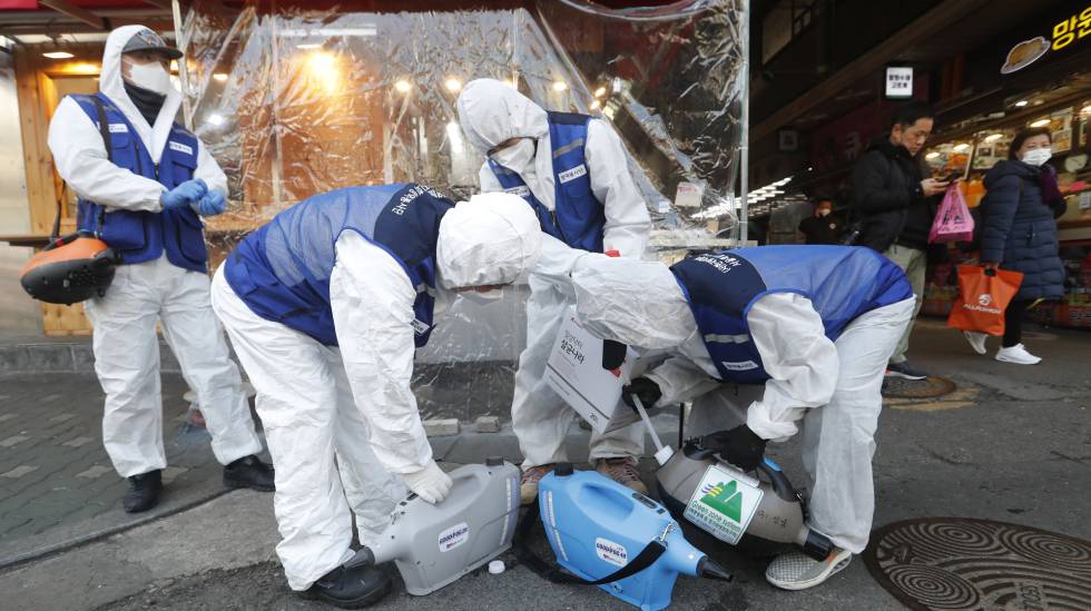 Un grupo de trabajadores rocía desinfectante en un mercado de Seúl este lunes. 
