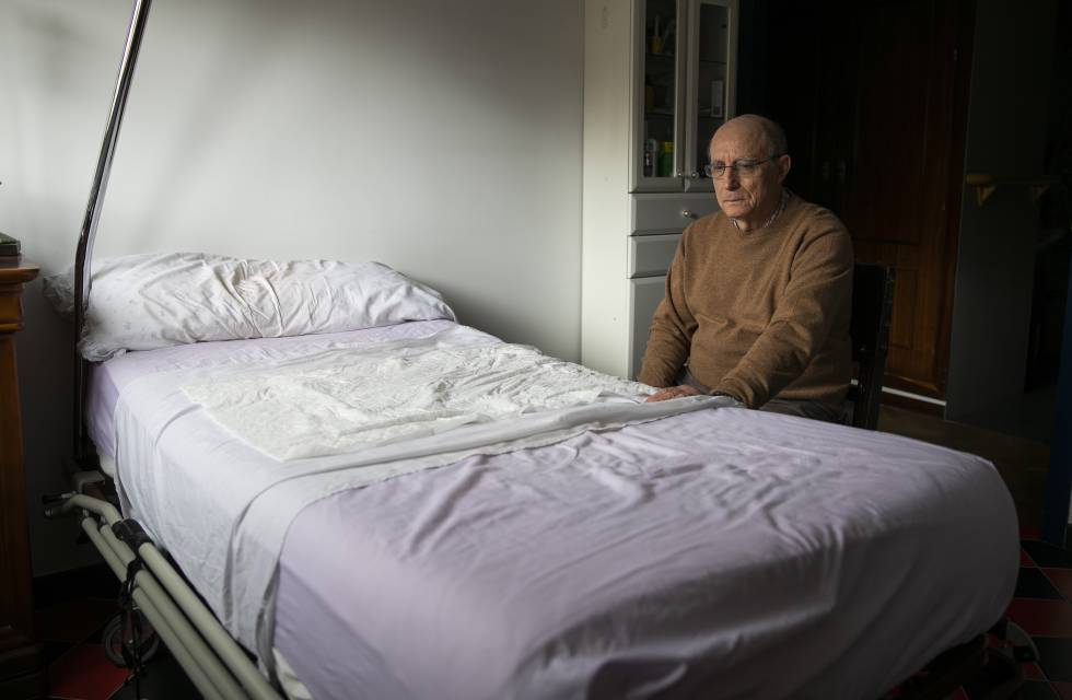 Ángel Hernández, junto a la cama en la que ayudó a morir a su mujer, María José Carrasco, enferma de esclerosis múltiple, en su casa de Madrid. 