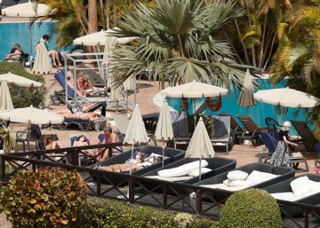 Varios turistas confinados en el hotel Costa Adeje Palace de Tenerife toman el sol con mascarillas, este miércoles.