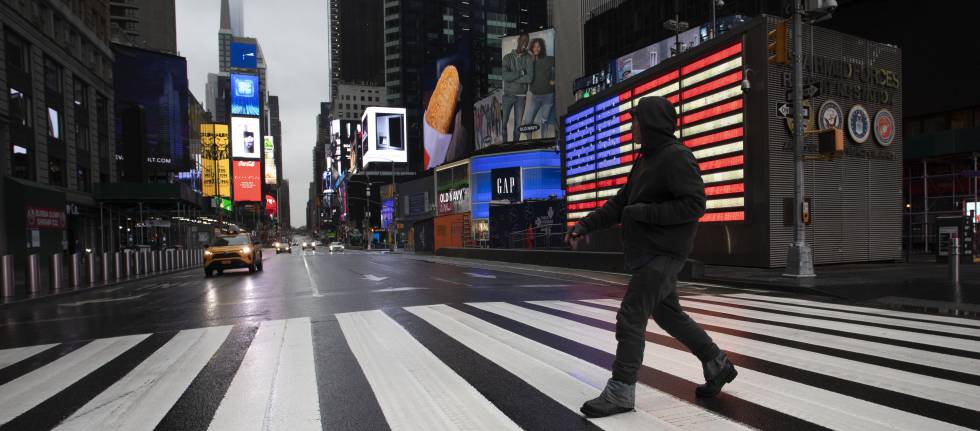 Un hombre cruza Times Square, en Nueva York, donde el alcalde ha pedido a los ciudadanos que se queden en casa para evitar la propagación del coronavirus.