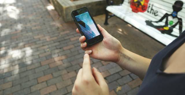 Una mujer utiliza un tel&eacute;fono m&oacute;vil. 