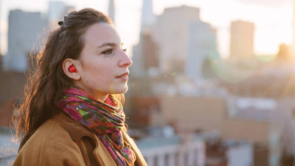 Una mujer, con un auricular inalámbrico.