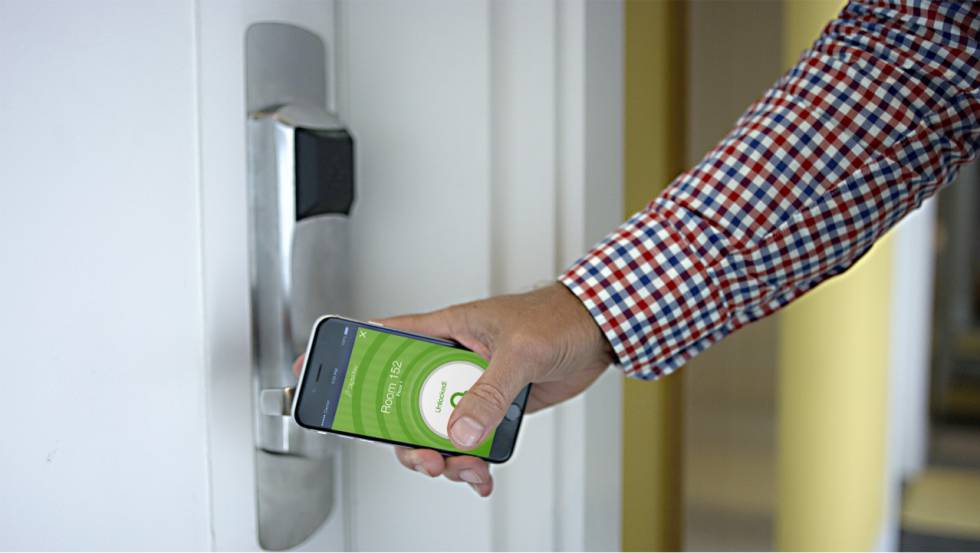 Un usuario abre la puerta de su hotel con una llave digital.