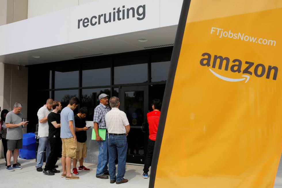 Un grupo de personas, en su mayoría hombres, hace cola para el 'Día del Trabajo en Amazon', en Fall River (Massachusetts, EE UU), en agosto de 2017.