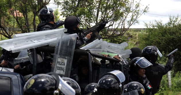 Foto que muestra a policías federales utilizando armas durante el desalojo de maestros en Oaxaca el 19 de junio. La agencia Xinhua envió la imagen a Aristegui Noticias para se comprobara su autenticidad a raíz de las declaraciones del gobierno. Max Núnez (Xinhua)