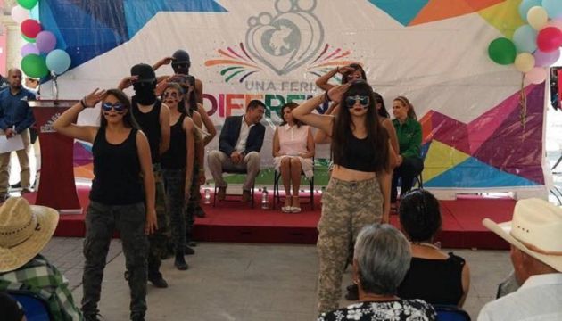 Cristina Rodríguez (al fondo, vestida de rosa) observa a los estudiantes bailar a ritmo de una canción de Will.i.am y Justin Bieber