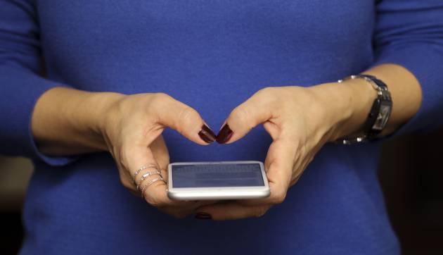 Una mujer mirando el m&oacute;vil en una foto de archivo