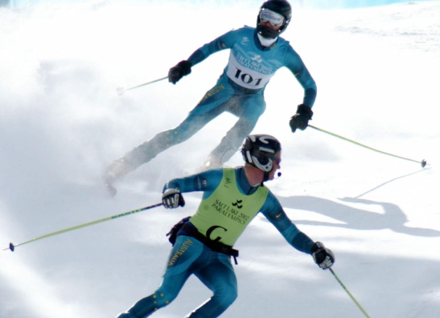 Un guía (delante) da indicaciones a través del micrófono a su esquiador en una prueba de esquí alpino
