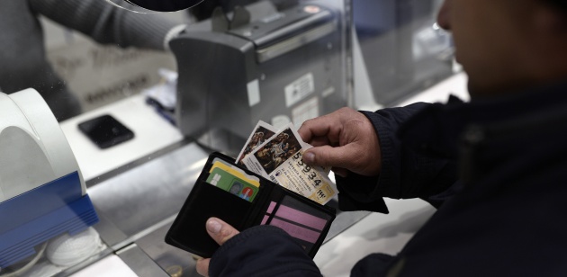 Una persona guarda sus décimos de lotería en la cartera