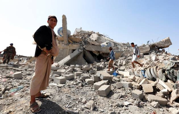 Varios hombres inspeccionan escombros de un edificio destruido a las afueras de Saná, Yemen, el 10 de mayo de 2018