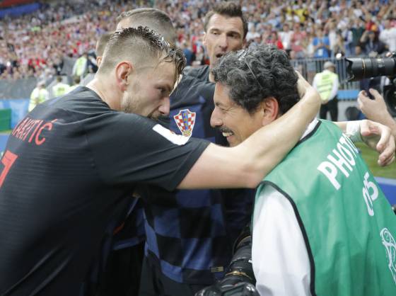 Iván Rakitic (esquerda) se desculpa após chocar-se com o fotógrafo Yuri Cortez (direita) na comemoração do gol de Mario Mandzukic.