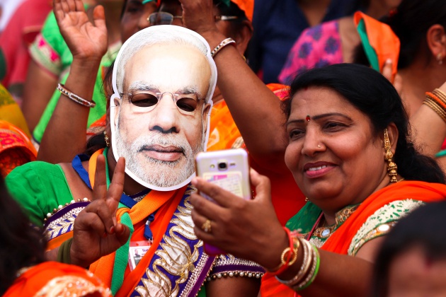 Un simpatizante del Bhartiya Janta Party (BJP) con una máscara del Primer Ministro, Narendra Modi