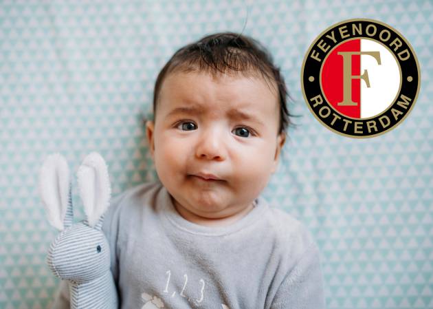 Un bebé, en una foto de archivo, junto a un escudo del Feyenoord