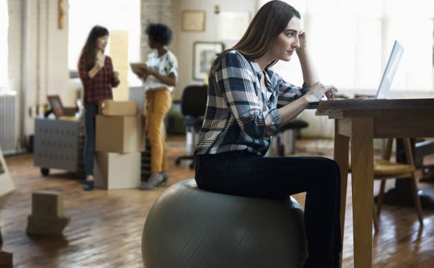 Una mujer sentada en su fitball