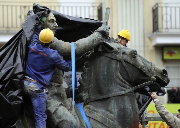 Unos trabajadores cubren una estatua ecuestre de Franco antes de su retirada en Santander en 2008