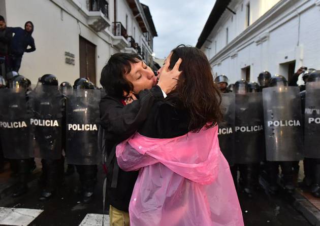 Una pareja se besa en una manifestación frente a la policía en Ecuador, en 2015