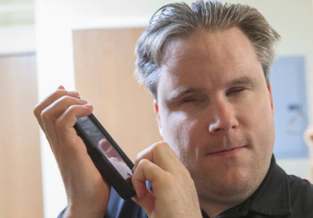 Una persona ciega, usando un dispositivo móvil